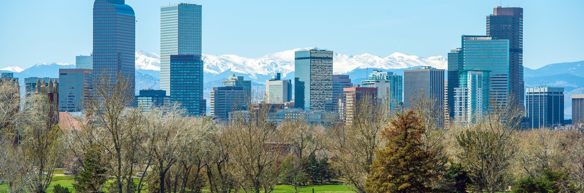 a city with trees and mountains in the background