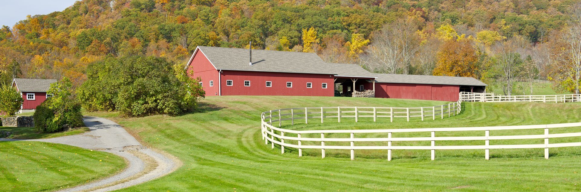 a red barn with a white fence in front of it