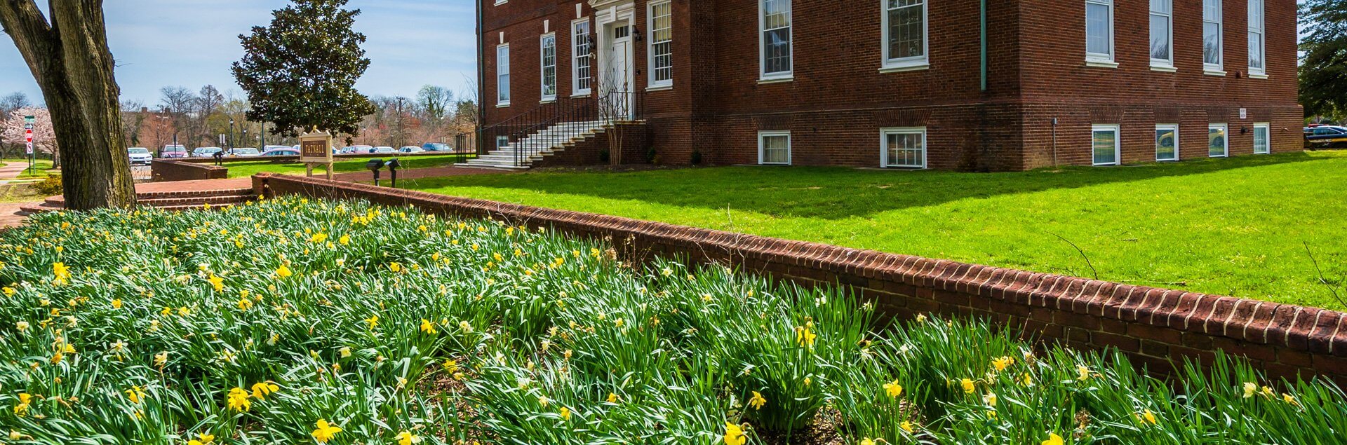 a brick building with a lawn and flowers