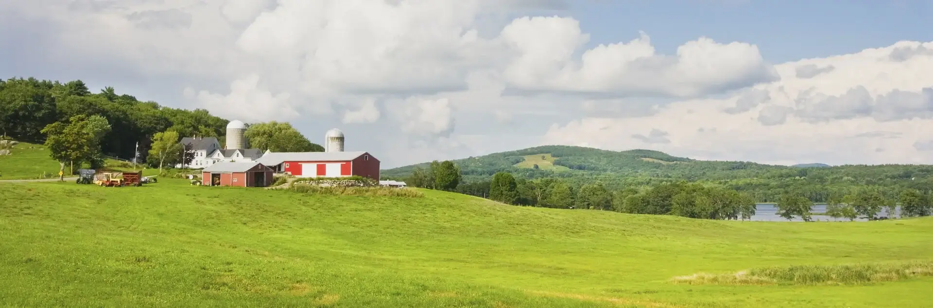 a red barn on a green hill