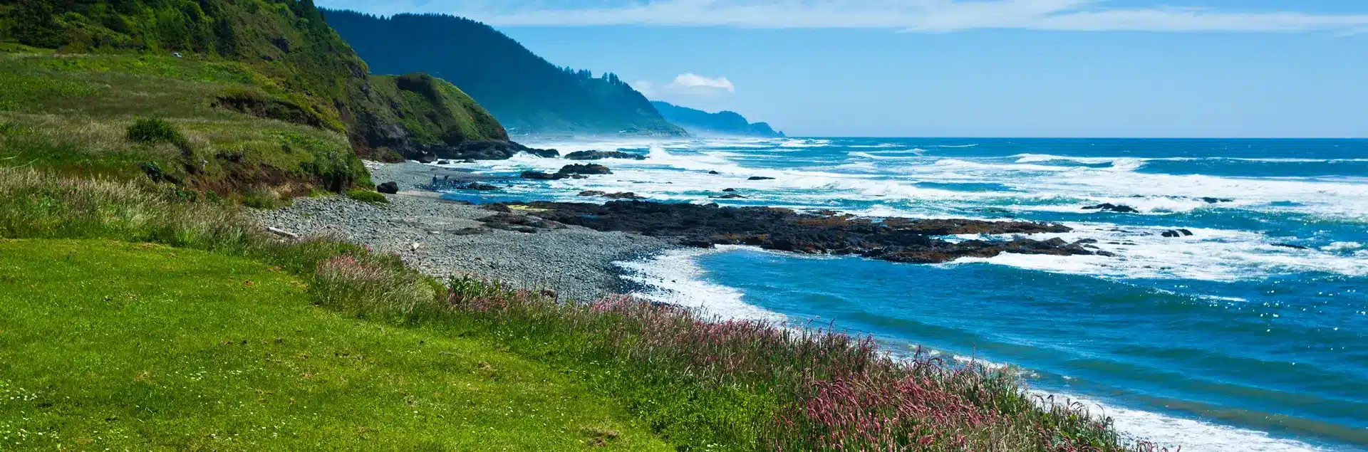 a rocky beach with waves crashing on the shore