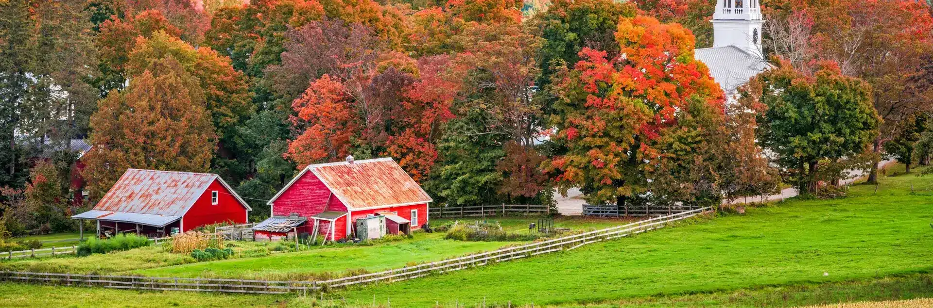 a red barn in a field with trees in the background